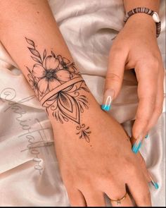 a woman's hand with a flower tattoo on it