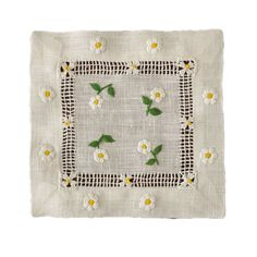 an embroidered square with white flowers and green leaves on the edges, in front of a white background