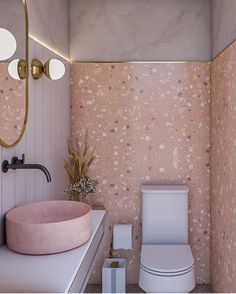 a bathroom with pink and gold decor on the walls, toilet and sink in it