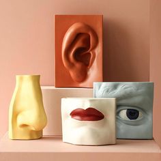 three ceramic vases with different shapes and sizes on top of a shelf next to each other