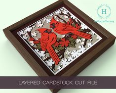 a red bird sitting on top of a piece of paper in a wooden frame with the words layered cardstock cut file