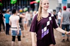 a woman in a purple shirt is holding hands with other people at an outdoor event