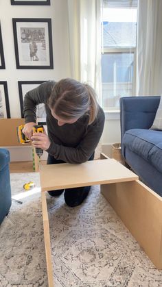 a woman is working on a table in her living room