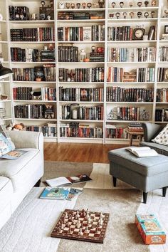 a living room filled with lots of furniture and bookshelves covered in shelves full of books