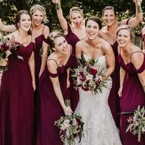 a group of women standing next to each other holding bouquets and posing for the camera