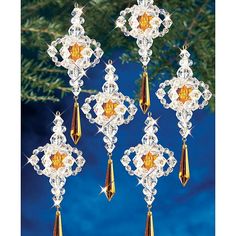 six ornaments hanging from a christmas tree with gold and orange beads on it's sides