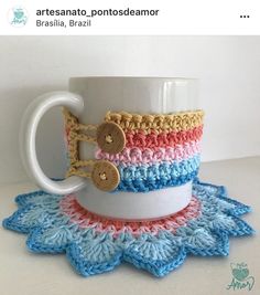 a coffee cup is sitting on a doily with some buttons in the mug holder