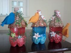 three colorful vases with birds and flowers on them sitting on a table in front of a window