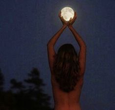 a naked woman holding up a white ball in the air with her hands above her head