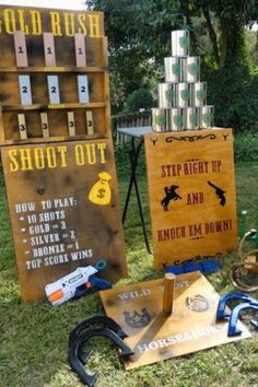 an assortment of items are on display in the grass near a sign that says shoot out