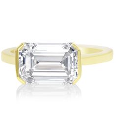 an emerald - cut diamond ring in yellow gold