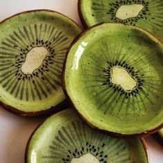 four green kiwi plates sitting on top of a white countertop next to each other