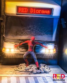 a spider man standing in front of a bus with the word red diorama on it