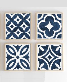 four blue and white tiles mounted on a wall