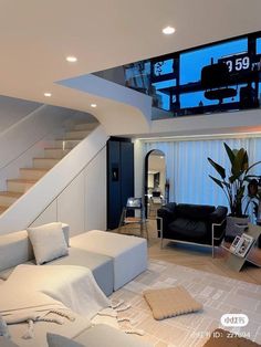 a living room with white couches and stairs