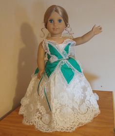 A magical, one of a kind ballgown for 18 inch dolls. This outfit comes in two pieces: 1.) The Dress: A gorgeous off white satin dress with organza and lace overskirts and a bodice made of crushed green satin petals/leaves trimmed with lace and pearls. Features handmade 3D chiffon flowers along the lower edge of the skirt. Has hook-and-loop tape in the back for ease of closure. 2.) The Veil: An off-white organza veil trimmed with handmade 3D chiffon flowers and gothic lace. Secures to doll's hair via bobby pin (included). Lace Princess Dress Ball Gown For Dress-up, Debutante Ball Princess Dress With Lace Bodice, Lace Princess Dress For Debutante Ball, Green Ball Gown For Wedding, Green Ball Gown For Wedding Pageant, Green Ball Gown Pageant Dress For Wedding, Lace Bodice Ball Gown Pageant Dress, Lace Ball Gown Pageant Dress With Lace Bodice, White Lace Pageant Dress With Lace Bodice