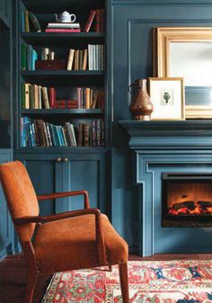 a living room filled with furniture and a fire place in the middle of a book shelf