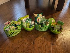 several green baskets filled with cleaning products on the floor in front of a wooden table