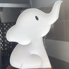 a large white elephant sculpture sitting on top of a wooden table