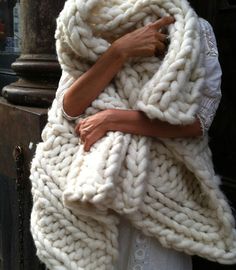 a woman wrapped in a large chunky blanket