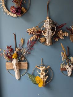 three wall hangings decorated with flowers and animal heads on blue walls in a room