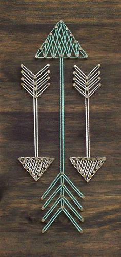 three metal arrows on a wooden surface