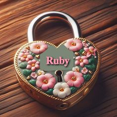 a heart shaped lock with flowers painted on it and the word ruby written in pink