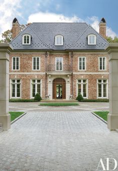 a large brick house with an entrance way leading to the front door and side entry