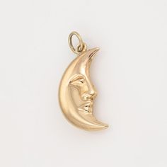 Finely detailed Man in the Moon charm crafted in 18k yellow gold.    The nicely detailed charm is rendered in lifelike detail with the image of the Man in the Moon appearing on both sides. The hollow charm has a lightweight feel to the touch at 1.6 grammes.   The charm is in very good condition and was lightly cleaned and polished.   Particulars:  Weight: 1.6 grammes  Stones:  N/A  Size & Measurements: The charm is small in scale and measures 1 x 1/4 inches (including the bale).  Metal & Hallmar Gold Moon Charm Pendant, Gold Moon Pendant Charm, Gold Crescent Jewelry With Charms, Yellow Gold Moon-shaped Charm Jewelry, Yellow Gold Moon-shaped Jewelry With Charms, Elegant Yellow Gold Moon Charm, Yellow Gold Moon Charm As Gift, Yellow Gold Moon Charm For Gift, Moon-shaped Yellow Gold Brass Jewelry