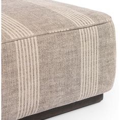 a close up of a footstool with stripes on it's fabric cover