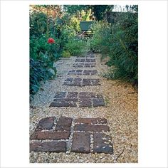 a stone path in the middle of a garden