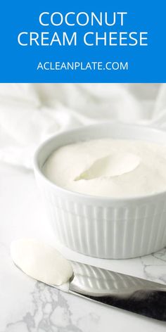 a white bowl filled with cream sitting on top of a table next to a spoon