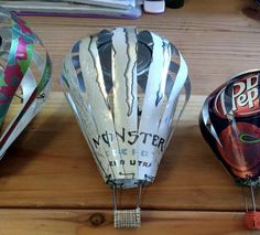 three hot air balloons sitting on top of a wooden table with price tags attached to them