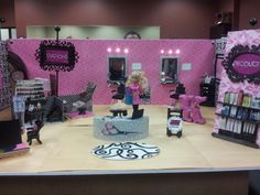 a doll store display with pink and black decor