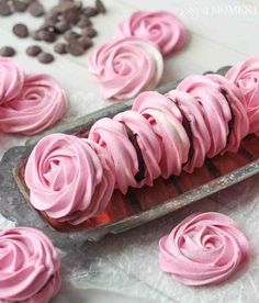 pink frosted cupcakes with chocolate chips on the side and in a baking tin