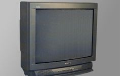 an old sony television sitting on top of a stand in front of a gray wall