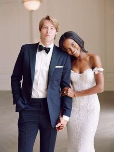 a man in a tuxedo standing next to a woman in a wedding dress