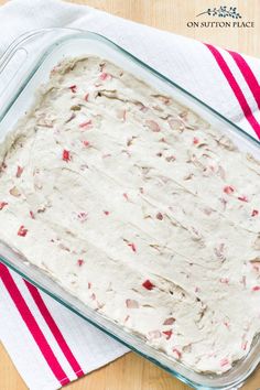 a glass baking dish filled with batter on top of a red and white striped towel