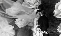 black and white photo of bride and groom in front of large paper flower backdrops