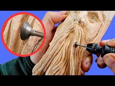 a man is carving wood with a drill and an object in front of his face