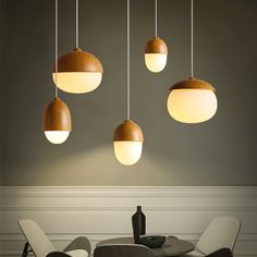 a dining room table with chairs and lights hanging from the ceiling