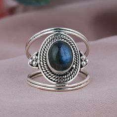 TITLE: -  Natural Labradorite Ring, Sterling Silver Jewelry, Boho Statement Ring, Wired Design Band Ring, Oval Shape Ring, Blue Flashy Gemstone Ring SPECIFICATIONS: - ❖ Metal:  925 Solid sterling silver ❖ Gemstone:  Labradorite ❖ Gemstone Size: 7x9  mm ❖ Total Weight:  5.7Gram ❖ Gemstone Setting: Bezel Note: Our use of natural stones may result in slight variations in texture and color in the actual product you receive, but the quality and grade of the stone remain consistent. FEATURES: -  * This stylish statement ring features a bezel-set oval labradorite on a  Wired Design Band Ring. The oval gemstone is a spectacle of shifting hues, reminiscent of the aurora borealis. The flanking 925 sterling silver clusters of metal ropes add texture and detailing to this labradorite solitaire ring. Oval Labradorite Promise Rings, Bohemian Stackable Gemstone Rings Oval Shape, Bohemian Oval Stackable Jewelry, Bohemian Oval Stackable Rings, Oval Stackable Bohemian Jewelry, Adjustable Oval Bohemian Rings, Spiritual Oval Stackable Rings, Adjustable Bohemian Oval Cabochon Ring, Bohemian Adjustable Oval Cabochon Rings