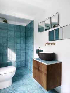 a bathroom with blue tiles on the floor and walls