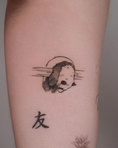 a panda bear tattoo on the arm with chinese characters around it's neck and behind its ear