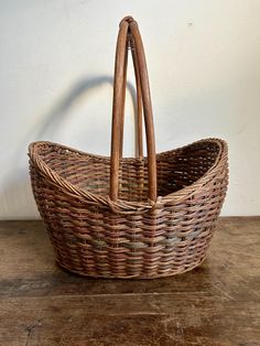 a wicker basket sitting on top of a wooden table next to a white wall