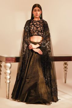 Black full sleeves padded blouse with sequin, thread, cutdana embroidery in a floral pattern and crystal drops on the waist. Paired with solid organza lehenga with attached cancan and border embroidered sheer dupatta.
Component: 3
Pattern: Embroidery
Type Of Work: Sequin, thread, cutdana, crystal
Neckline: Round
Sleeve Type: Full
Fabric: Tulle, Organza
Color: Black
Other Details: 
Lehenga Length : 44 inches
Attached double lining
Blouse with crystal drops on the waist and sleeve hems
Sheer dupat Cutdana Embroidery, Sheer Dupatta, Blouse Lehenga, Tulle Embroidery, Organza Lehenga, Padded Blouse, Black Tulle, Pattern Embroidery, Full Sleeves