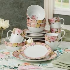 a table topped with plates and cups filled with flowers