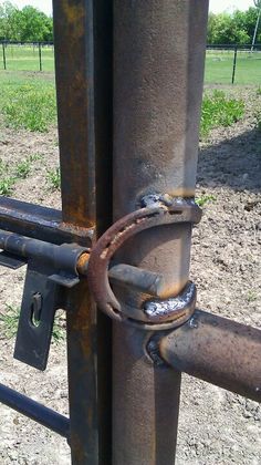 an old rusted metal gate is locked to the ground