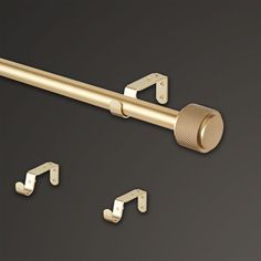 an image of a metal curtain rod and two hooks on a black background with space for text