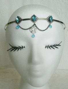 Blue Pentacle Circlet This beautiful circlet has three sterling silver plated filigree accents with aqua blue faceted glass settings, aqua blue glass bead drops, pewter silver pentacle and metal chain. An elegant headpiece. Adjustable. Gothic Blue Metal Jewelry, Blue Gothic Metal Jewelry, Silver Fantasy Jewelry For Festivals, Adjustable Fantasy Jewelry For Festivals, Adjustable Fantasy Festival Jewelry, Spiritual Silver Body Jewelry For Festivals, Gothic Adjustable Body Jewelry For Festivals, Adjustable Blue Festival Headpieces, Adjustable Blue Headpieces For Festivals